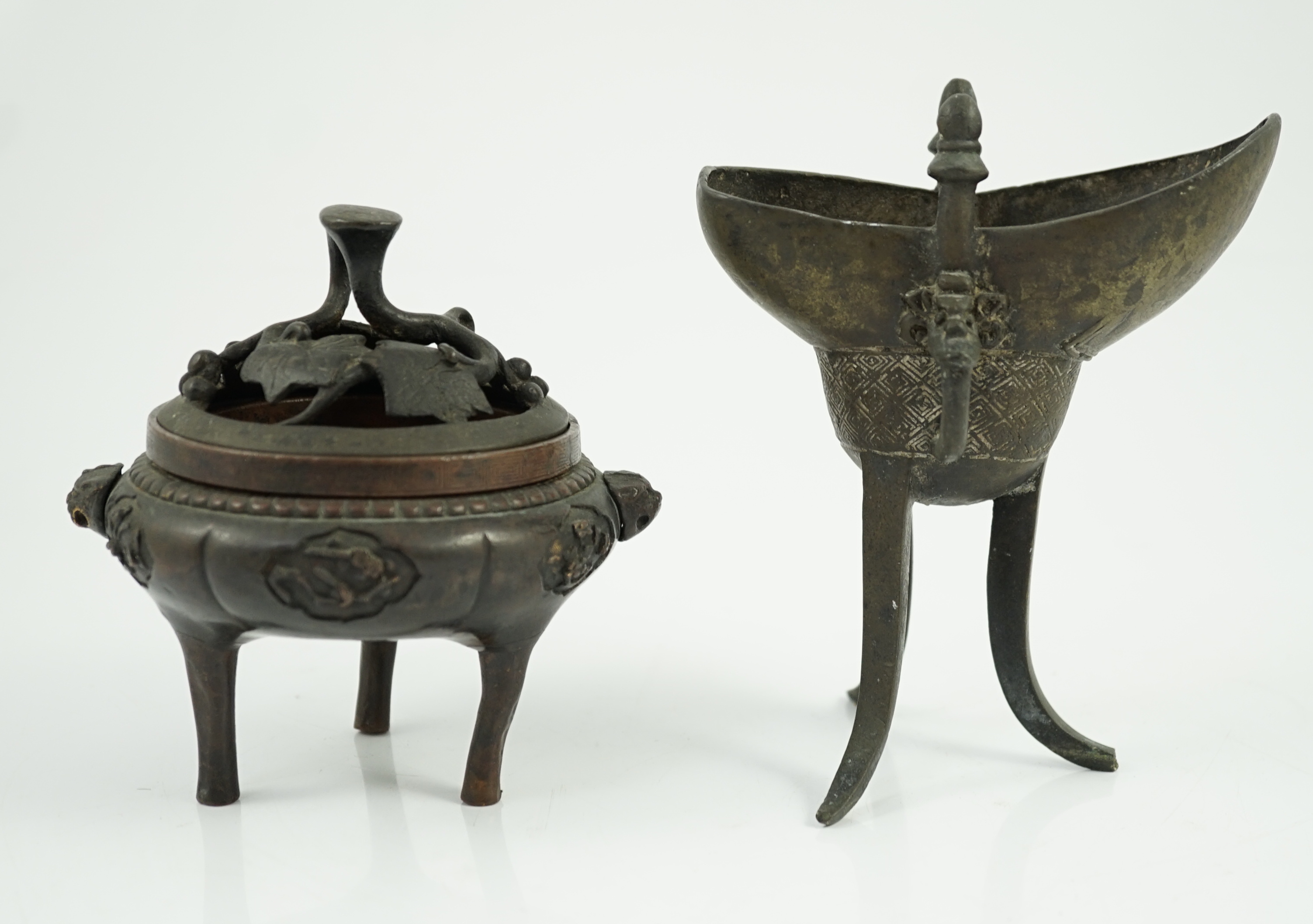 A Chinese bronze and copper alloy tripod censer and cover and a Chinese archaistic bronze tripod vessel, yi, both 17th century